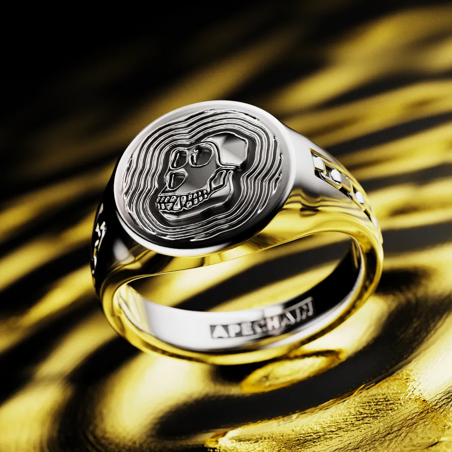 An ApeChain custom signet ring in silver, a skull crest on a band engraved APECHAIN