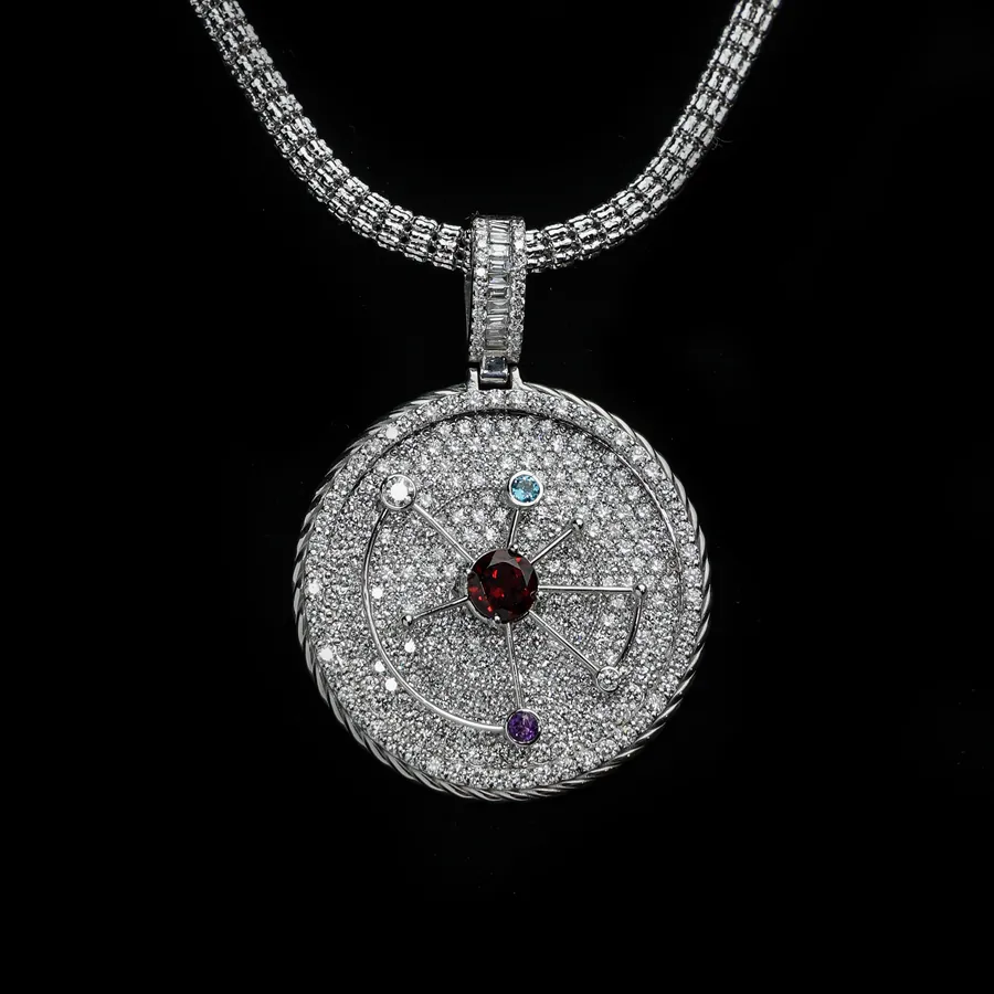 A full pavé medallion pendant with a red centre stone, hanging on a pavé chain