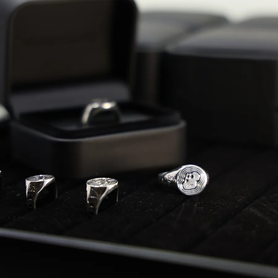 A row of ApeChain signet rings in a presentation case
