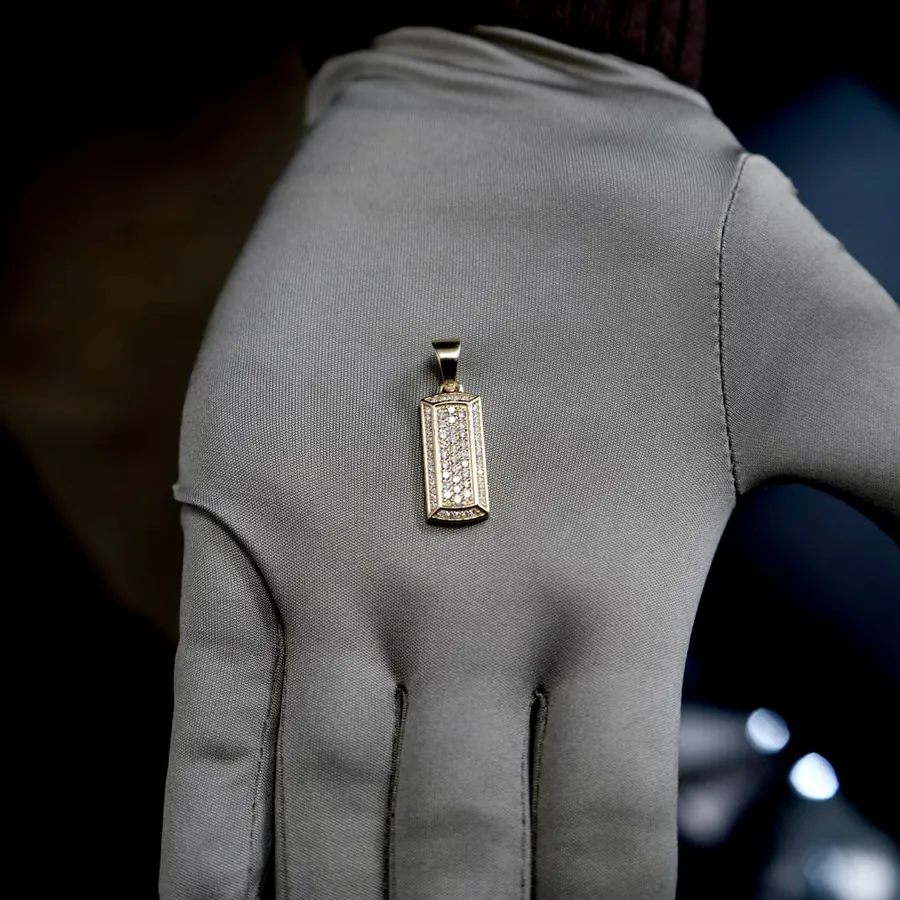 A diamond pavé ingot pendant held in a gloved hand